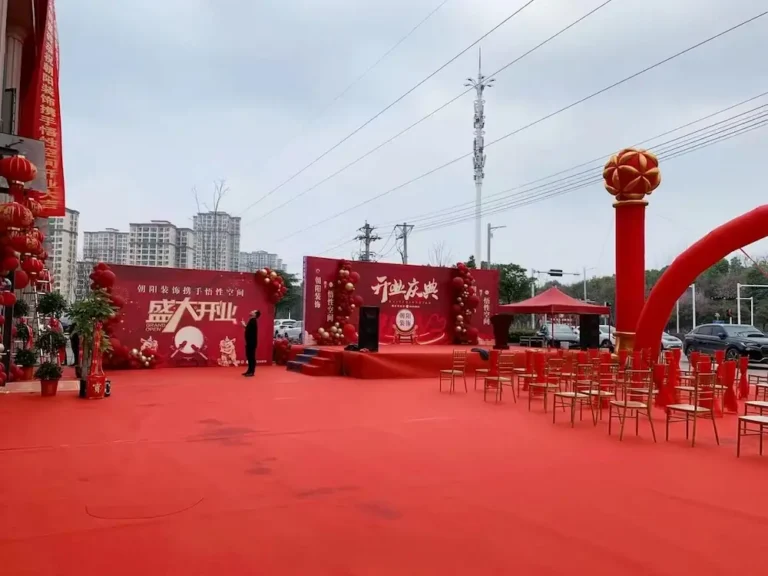 益阳开业庆典现场布置，红色主背景板、拱门与红毯签到区——天舜广告