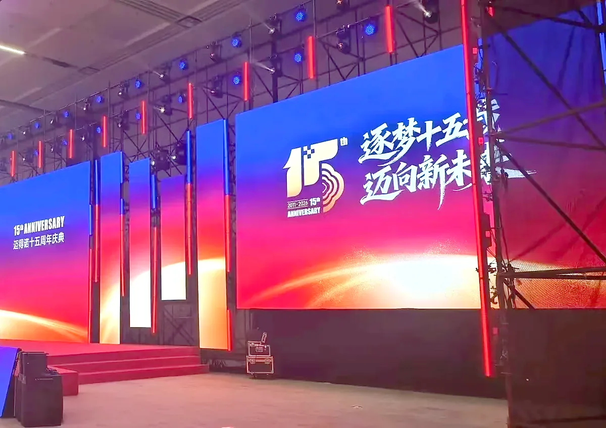 企业周年庆典活动舞台搭建实拍，红色主视觉大屏与灯光桁架布置，周年庆策划案例